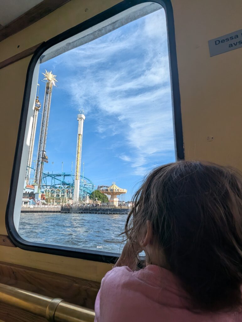 Little girl admiring Grona Lund from the ferry window in Stockholm