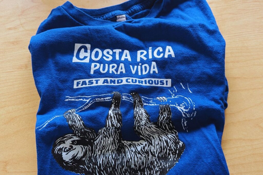 a TV shirt with a sloth with pura vida saying on it