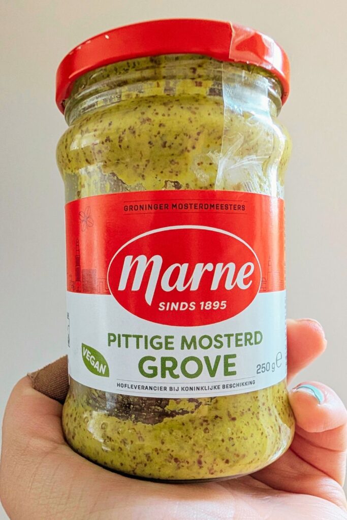 a hand holding a jar of Dutch mustard