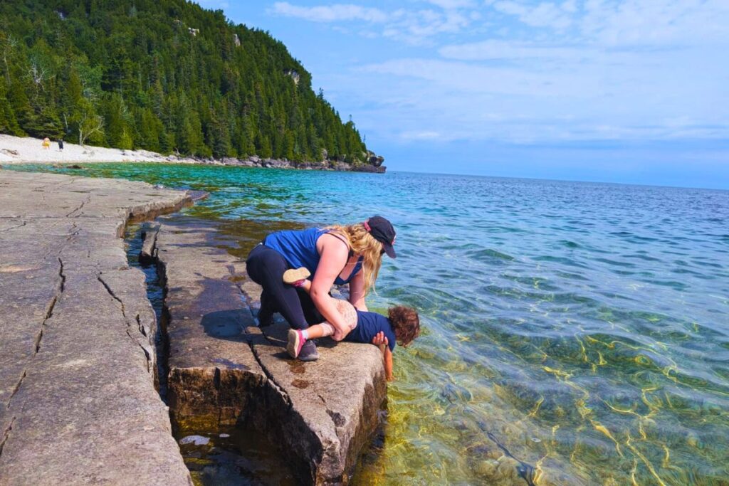 Helping my little one test the water off the shores of Flowerpot Island