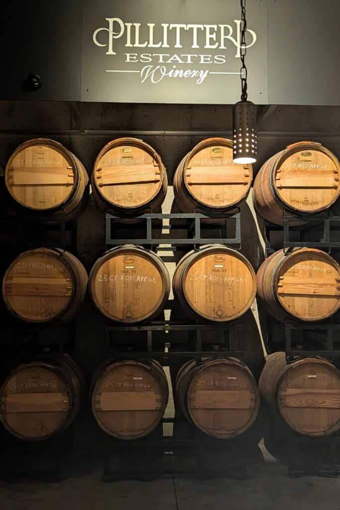 Pillittteri Estates winery sign with wine barrels full of ageing wine underneath
