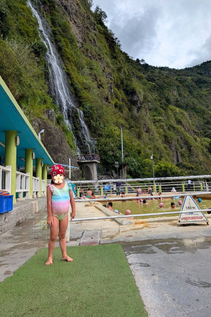 My daughter in front of Piscinas de Termas de la Virgen in Baños