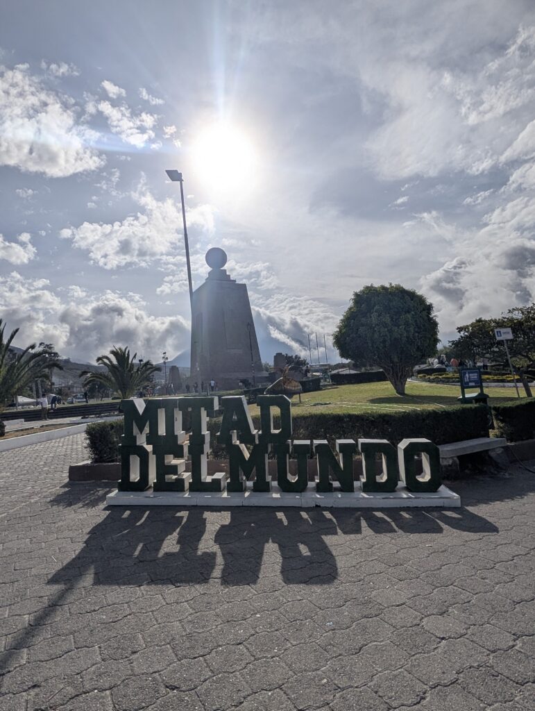 Mitad del Mundo sign with the iconic monument behind it