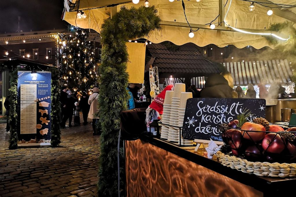 a vendor stall at the Riga Christmas market selling mulled wine and fresh apples