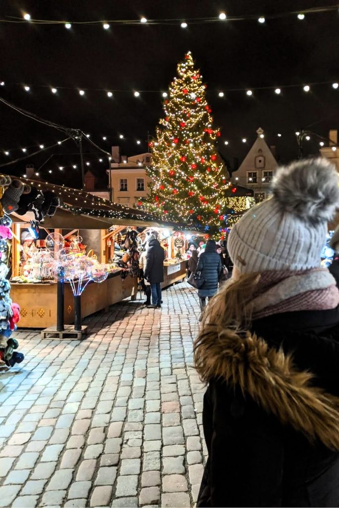 A woman looking at the Tallinn Christmas market